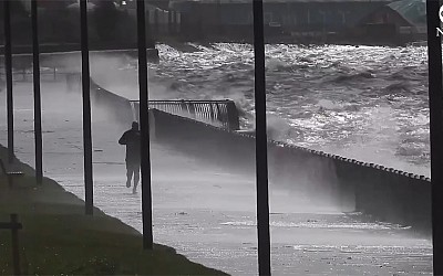 WATCH: Man calmly jogs along oceanfront as storm rages