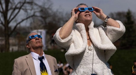 Hundreds of couples got married during the solar eclipse. Photos show mass weddings featuring moon-themed cakes and protective glasses.