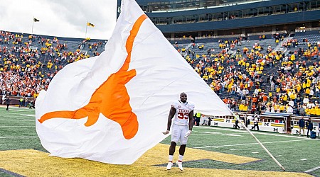 WATCH: Texas LB tries to plant Longhorns flag on midfield logo at Michigan Stadium after win over Wolverines