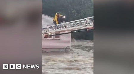 Firefighter crawls across ladder above floods to save woman