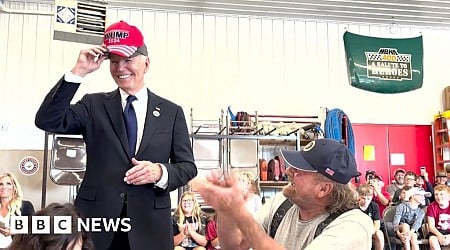 Moment Biden puts on red Trump 2024 hat