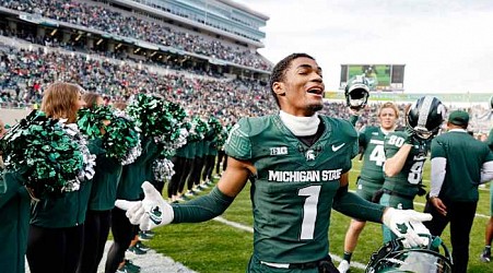 Michigan football player who transferred from Michigan State wears U of M cap to MSU graduation