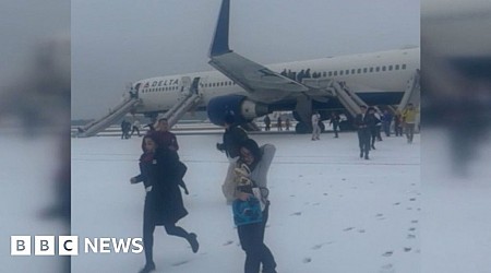 Passengers evacuate plane on snowy tarmac amid storm