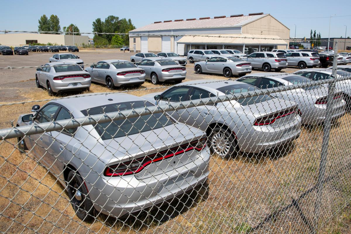 A fenced lot in Salem has dozens of silver Chargers and Durangos. Why is that?