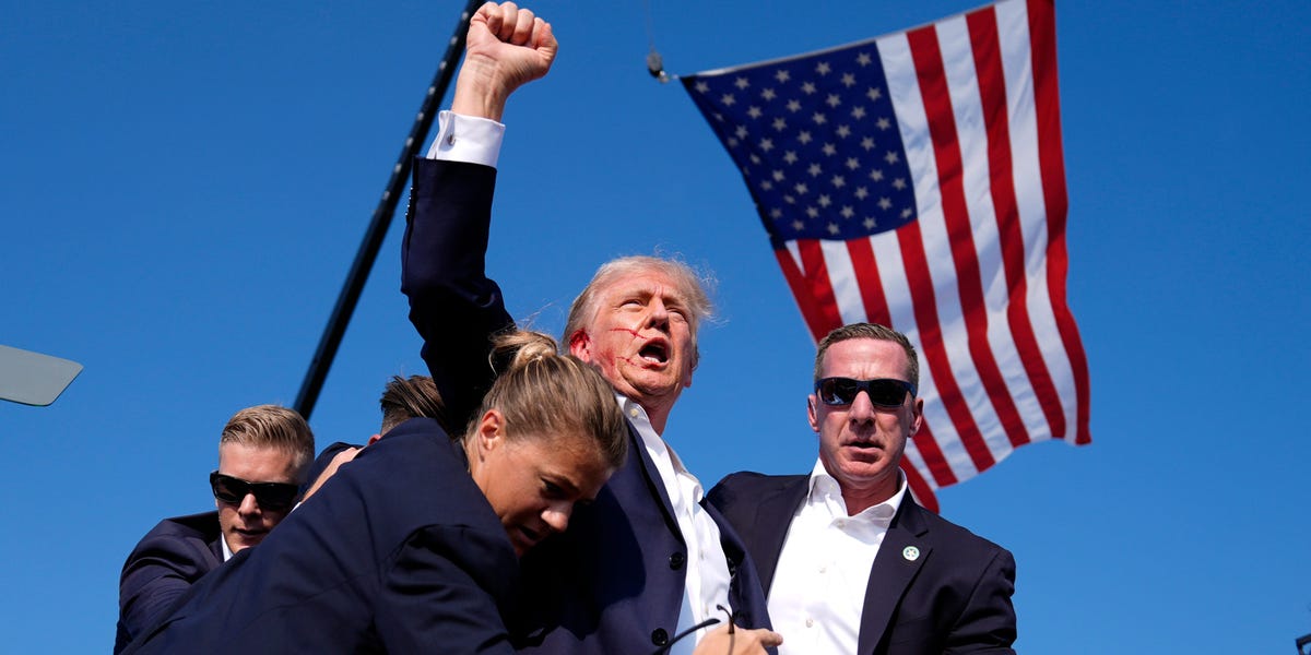 Photos show Trump, blood on his face, pumping his fist after an incident at his rally