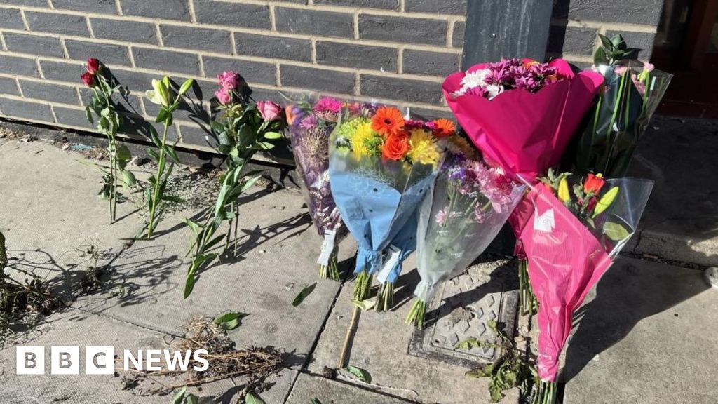 Tributes left as teen held over tower block deaths