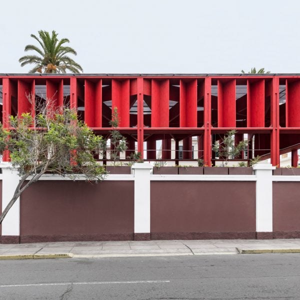 K+M Arquitectura y Urbanismo slots red pergola behind historic building in Peru