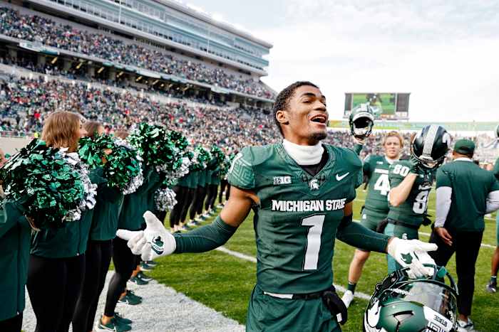 Michigan football player who transferred from Michigan State wears U of M cap to MSU graduation