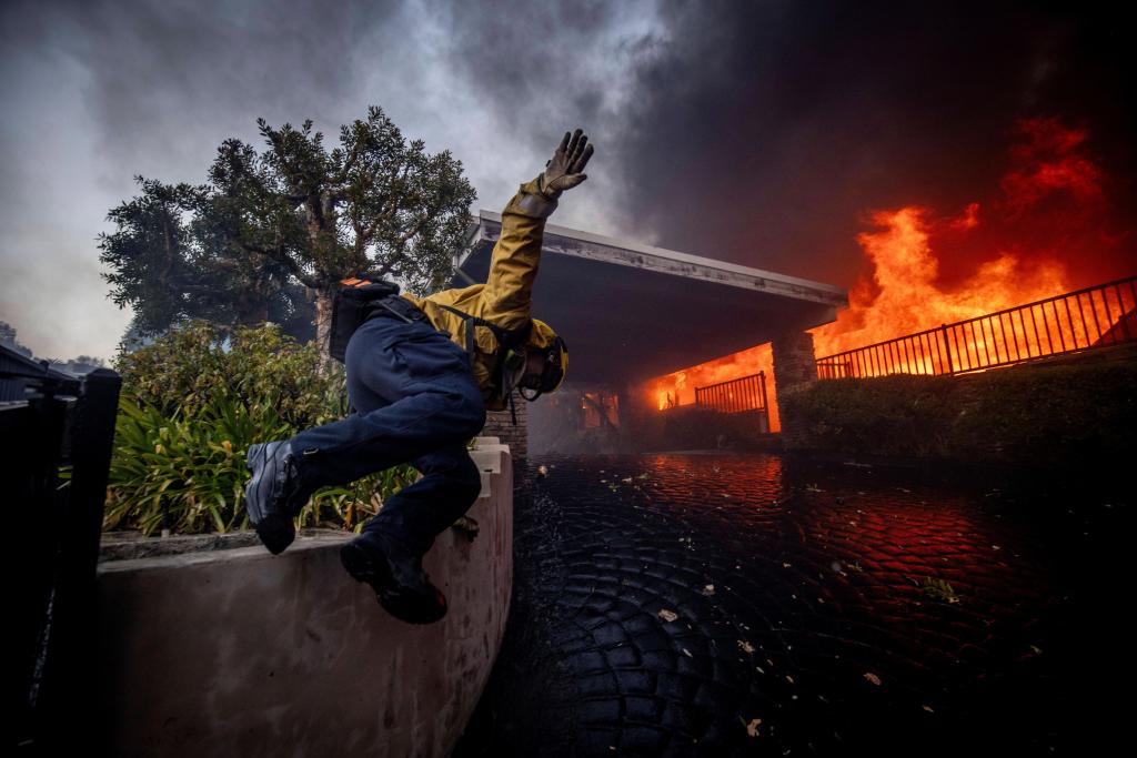 Thousands flee as wildfires burn out of control in and around Los Angeles and homes are destroyed